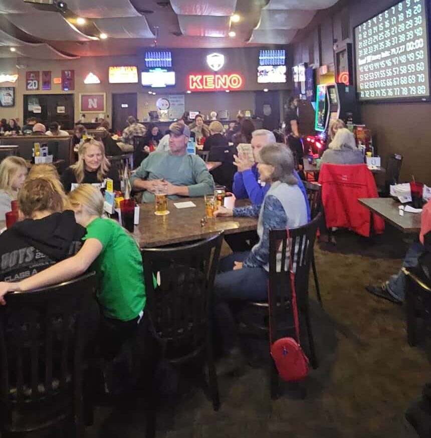 Friends laughing and playing trivia at a bar